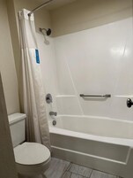 Un bagno con una vasca da bagno bianca, un water e una tenda da doccia.