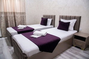 A hotel room with two beds, each with a headboard, a nightstand, and a curtain. - Art hommee (TASHKENT)