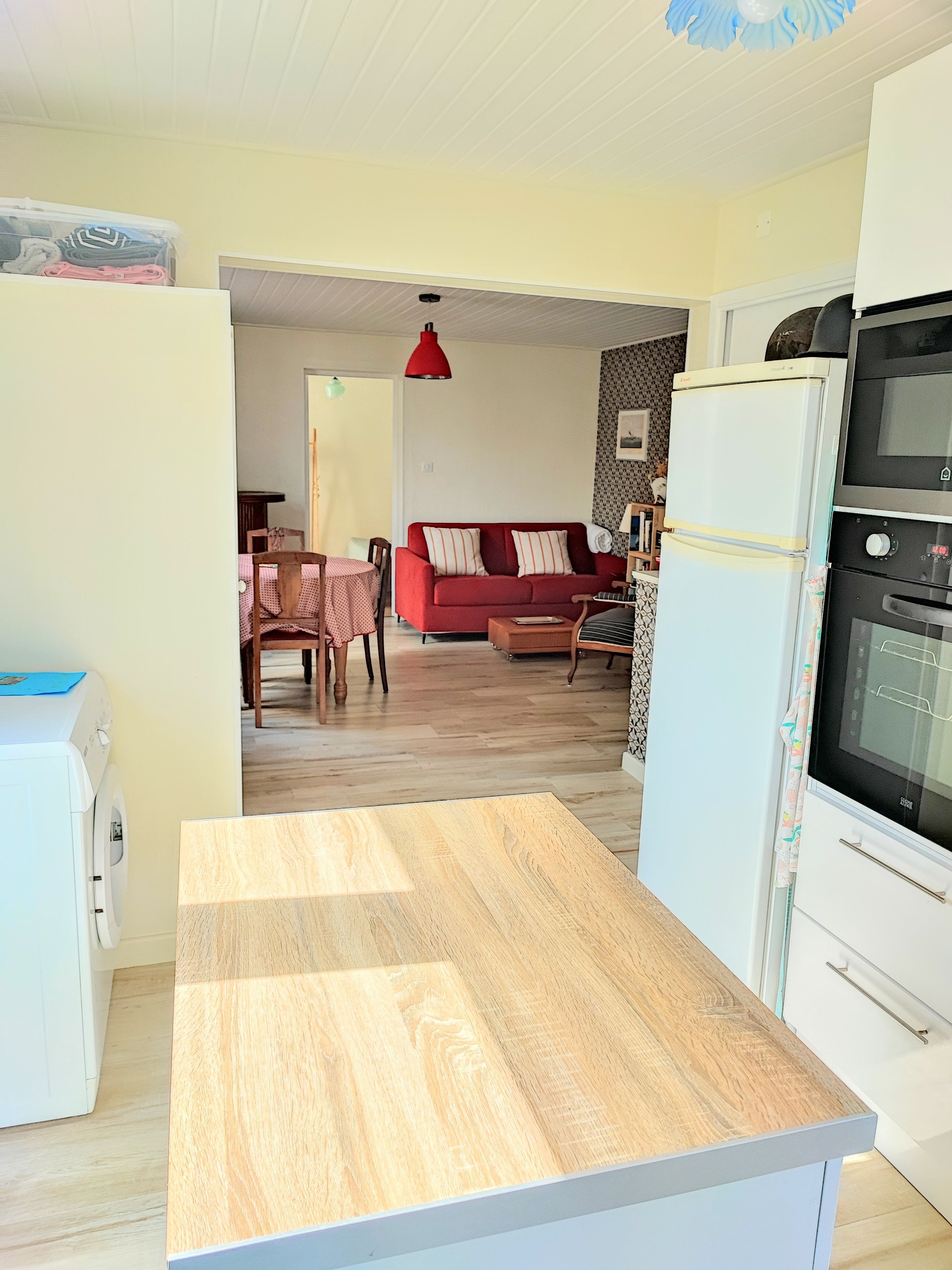 Una cocina con encimera de madera, un refrigerador blanco y un horno.