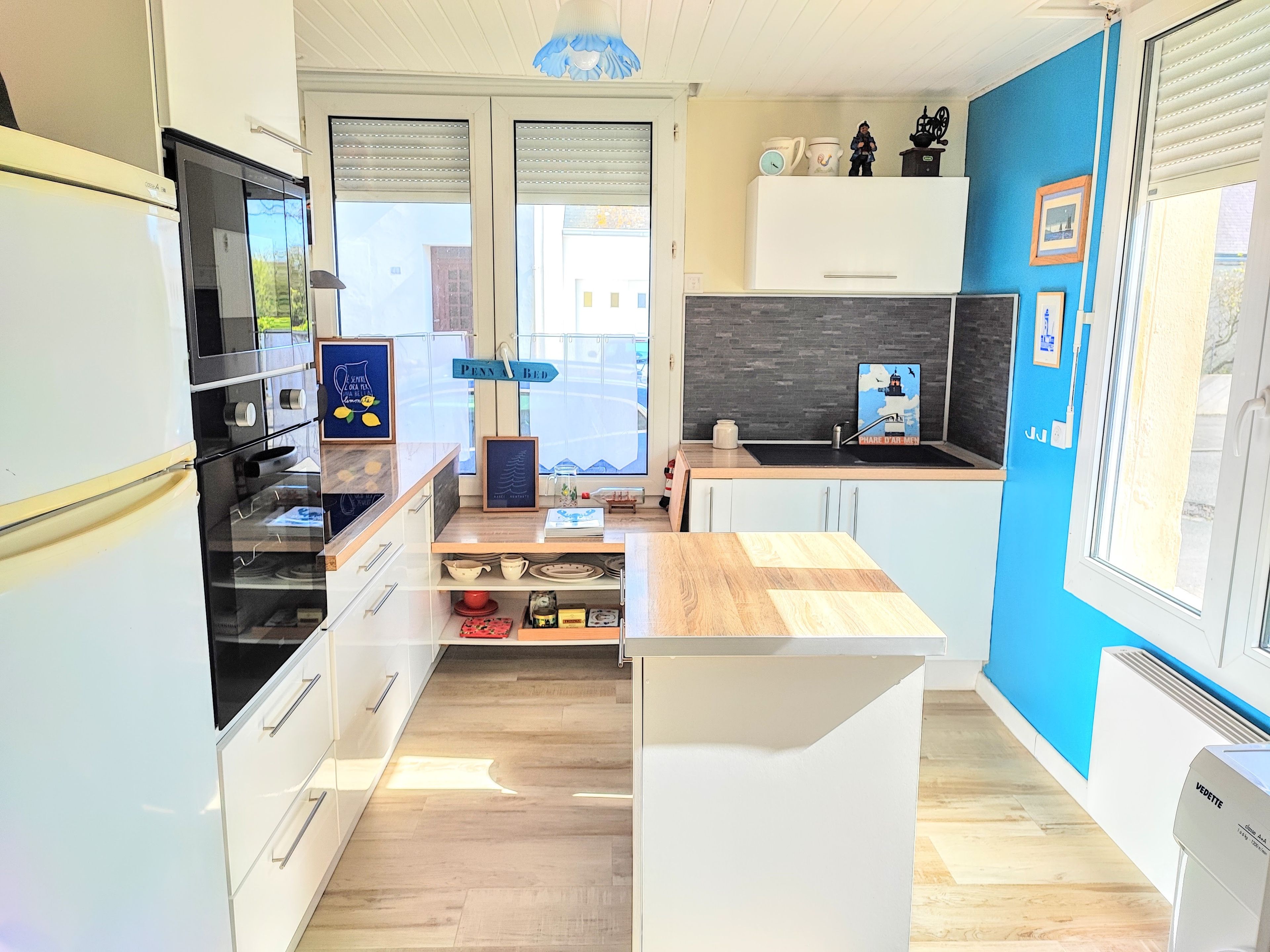 Una cocina moderna con armarios blancos, un horno negro y encimera de madera.