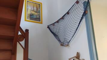 Una scala con ringhiere in legno, un'amaca fissata al muro e un quadro incorniciato.