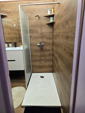 Une salle de bain moderne équipée d’une douche, de toilettes et d’un lavabo.