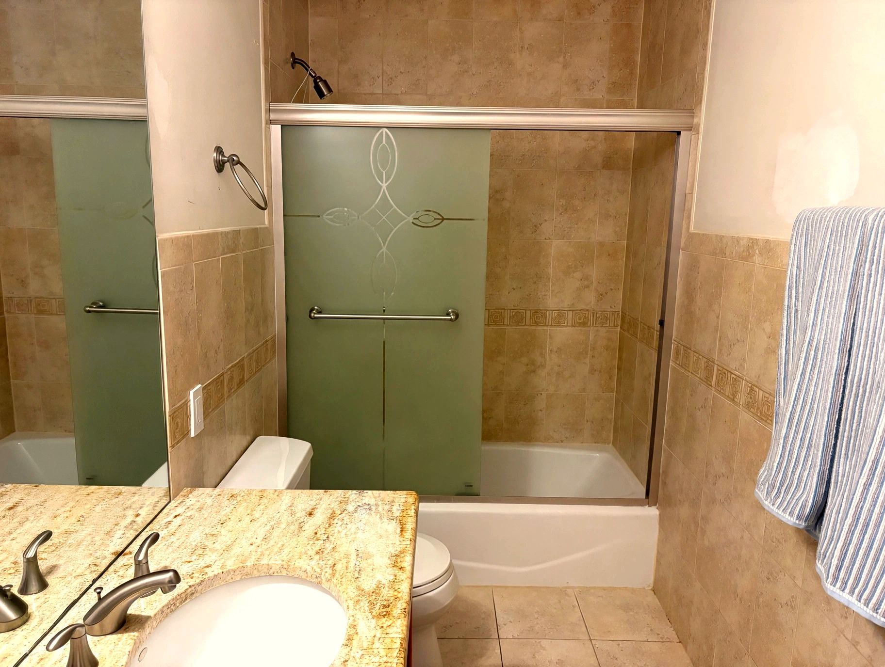 Ein Badezimmer mit Dusche, Toilette und Waschbecken.