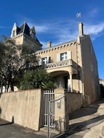 A large, historic building with a prominent tower and a gated entrance.