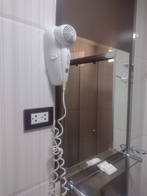 Un secador de pelo instalado en una pared con un enchufe debajo.