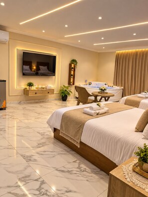 A modern hotel room with a large bed, a desk, a chair, a TV, and a bathtub. - Wateen Pyramids View (Giza)