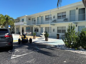 A two-story building with a parking area, a water fountain, and a sign for a waterpark. - Hideaway Waterfront Resort & Hotel (Cape Coral)