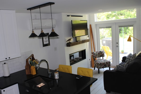 A modern kitchen with a black countertop, a built-in oven, and a flat-screen TV mounted above the oven.