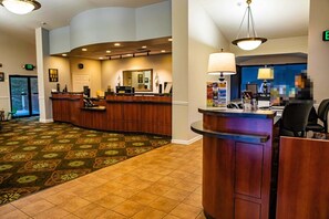 A hotel lobby with a reception desk, a large mirror, and a patterned carpet. - Pigeon Forge | Friends' Outdoor Escape | Hiking + Pool | 2BR Townhome (Pigeon Forge)