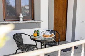 Un desayuno con una mesa, sillas y vista al exterior.