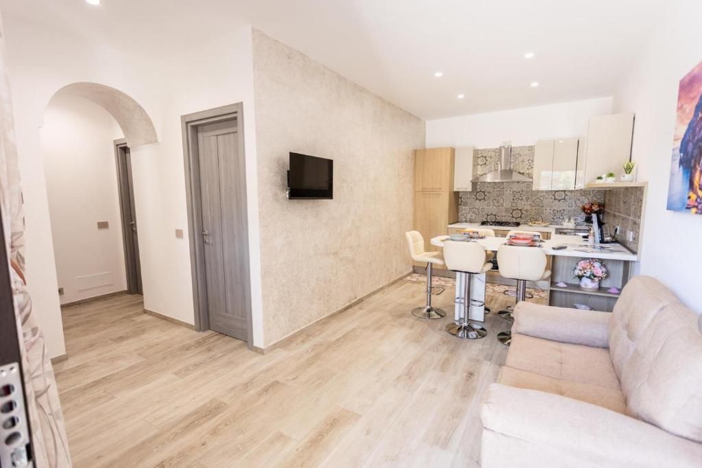 A modern living space with a kitchen, dining area, and a sofa.