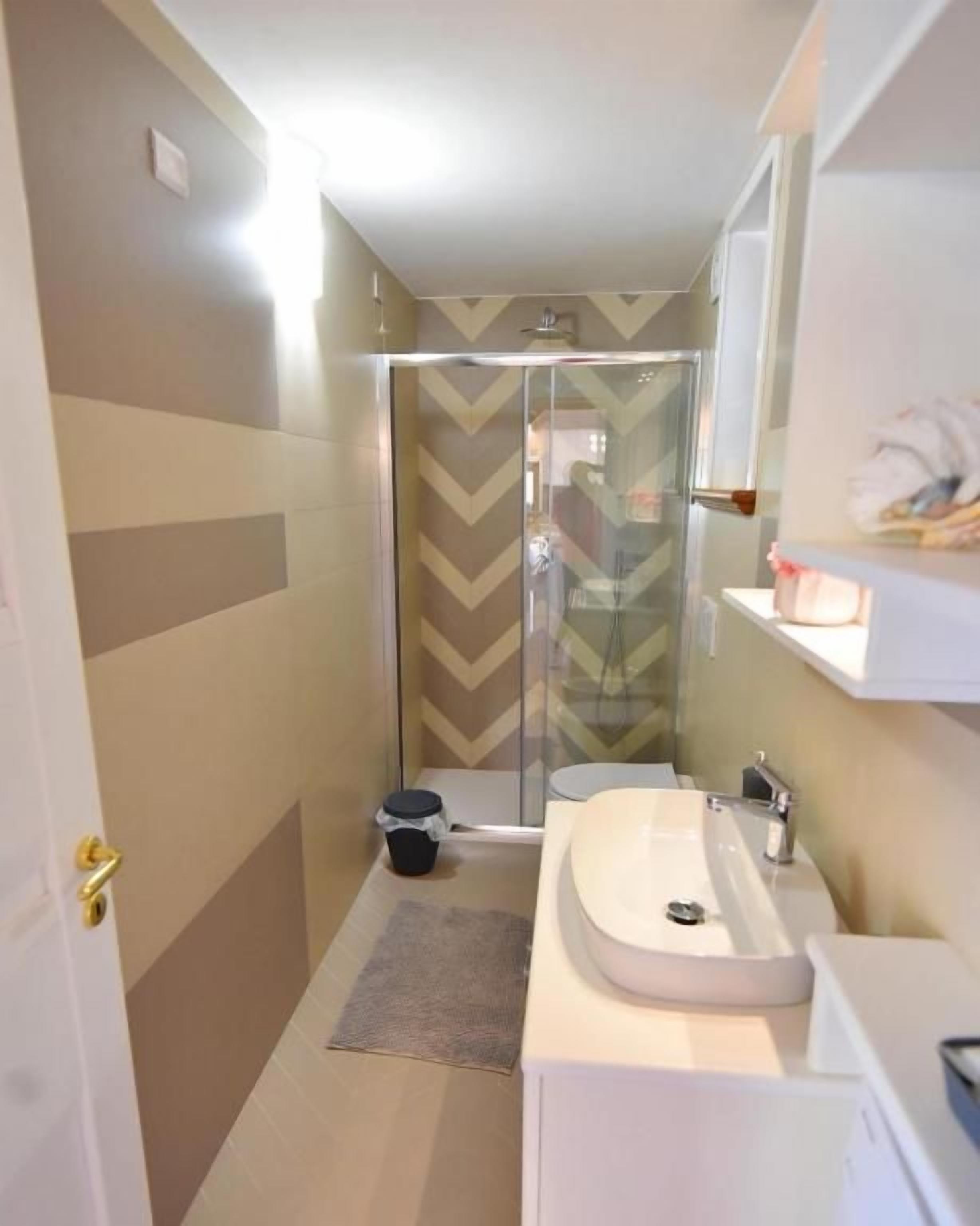 A bathroom with a shower, a sink, and a mirror.