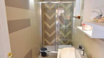 A bathroom with a shower, a sink, and a mirror.
