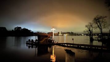 A dock extending into calm water with a small building and a slide.