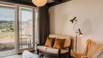 A modern living room with a sofa, a chair, a table, and a floor lamp.