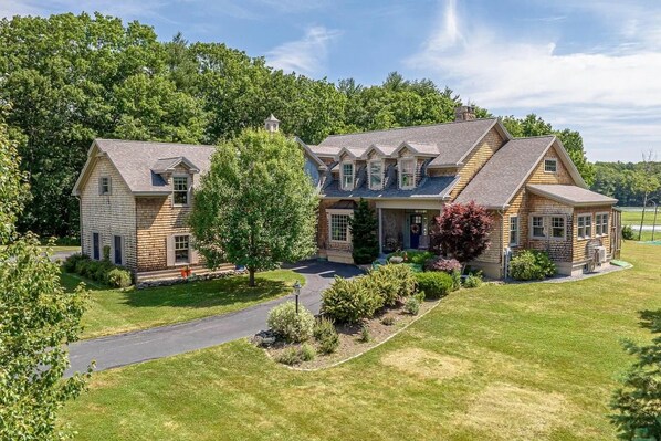 A two-story house with a front porch, a driveway, and a well-maintained lawn. - Spacious 4BR/4BA York Retreat w/ Big Backyard (York)