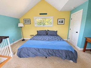 Une chambre à coucher avec un lit, une fenêtre, une porte et une lampe.
