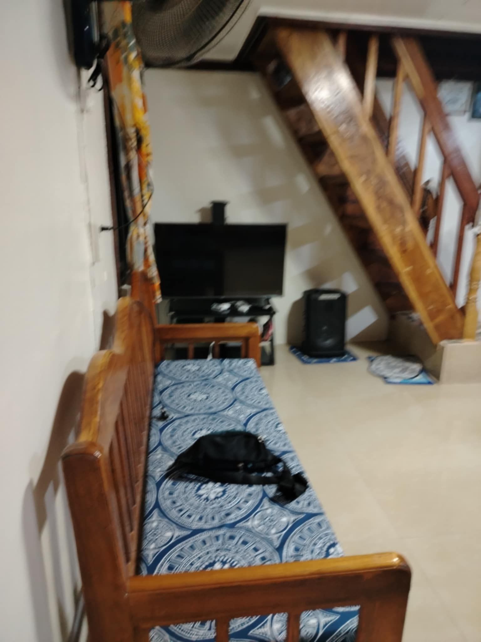 A room with a wooden bench, a television, and a speaker.