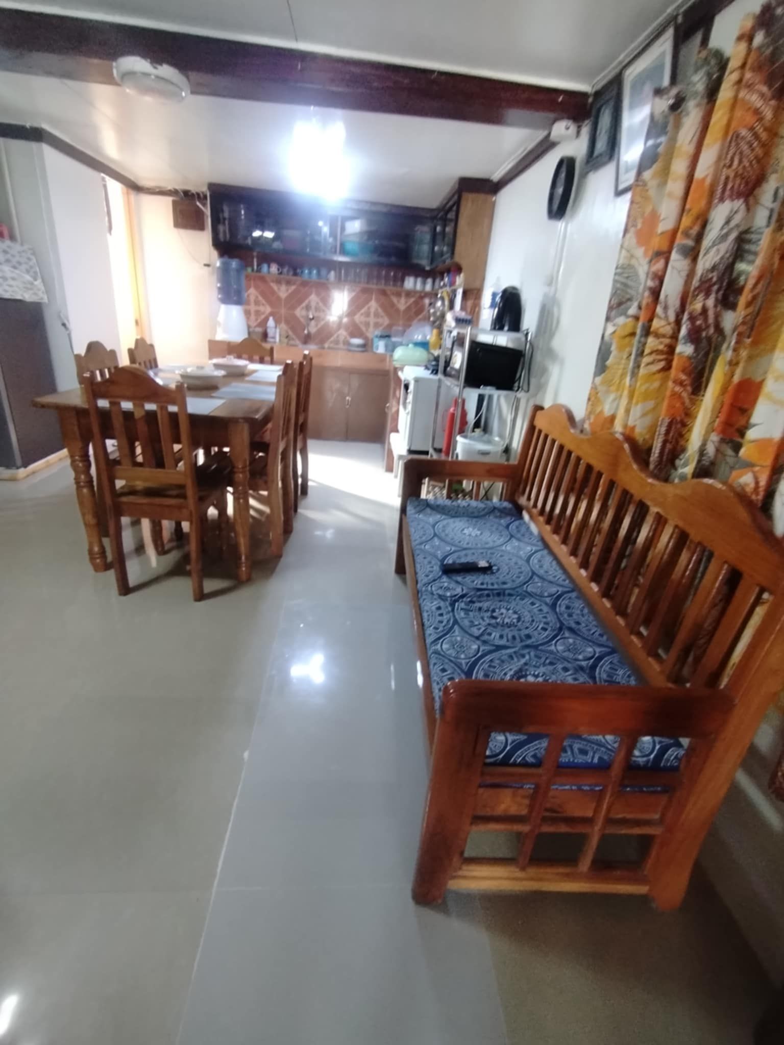 A dining area with wooden furniture and a patterned bench.
