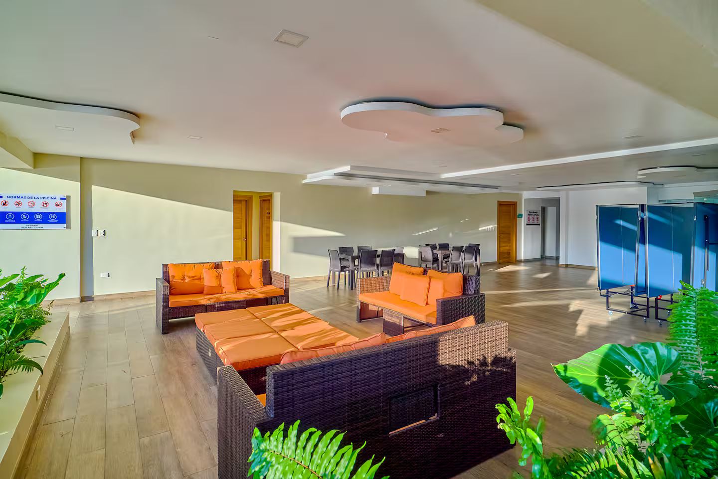 A spacious lobby with wicker furniture and a poolside area.
