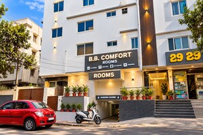 A hotel with a sign indicating B.B. Comfort Rooms, AC rooms, free WiFi, hot water, and parking. - Hotel BB Comfort Boarding By OTABoostup (Bengaluru)