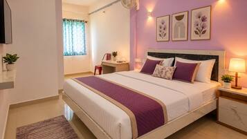 A modern bedroom with a bed, bedside tables, a desk, and a window with curtains.