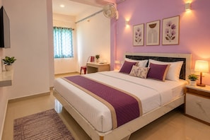 Un dormitorio moderno con cama, mesitas de noche, un escritorio y una ventana con cortinas.