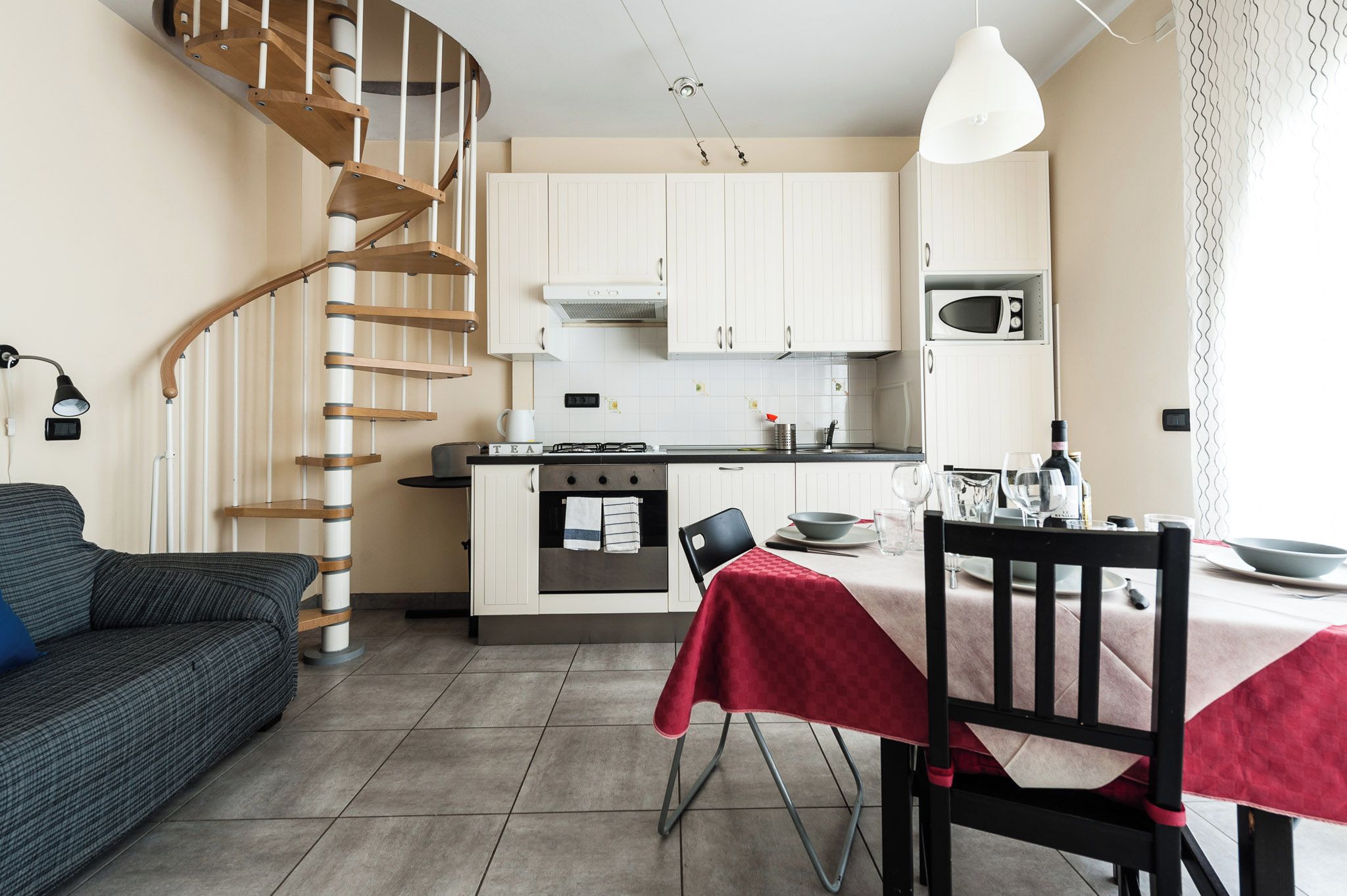 A modern kitchen with white cabinets, a built-in oven, and a microwave.