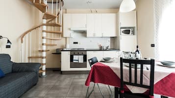 A modern kitchen with white cabinets, a built-in oven, and a microwave.
