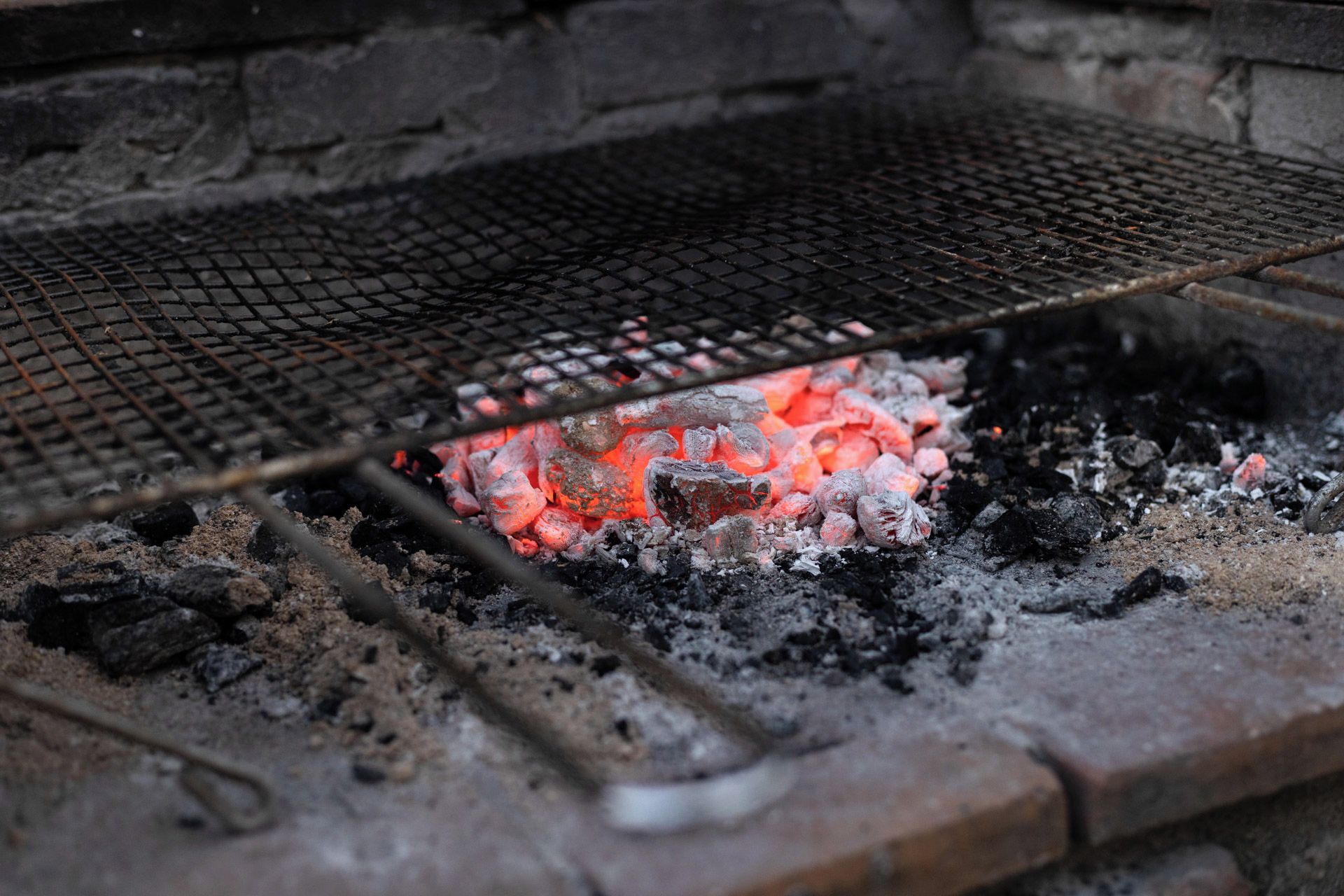 Ein Grill mit Holzkohle und glühenden Kohlen, der aktives Kochen signalisiert.