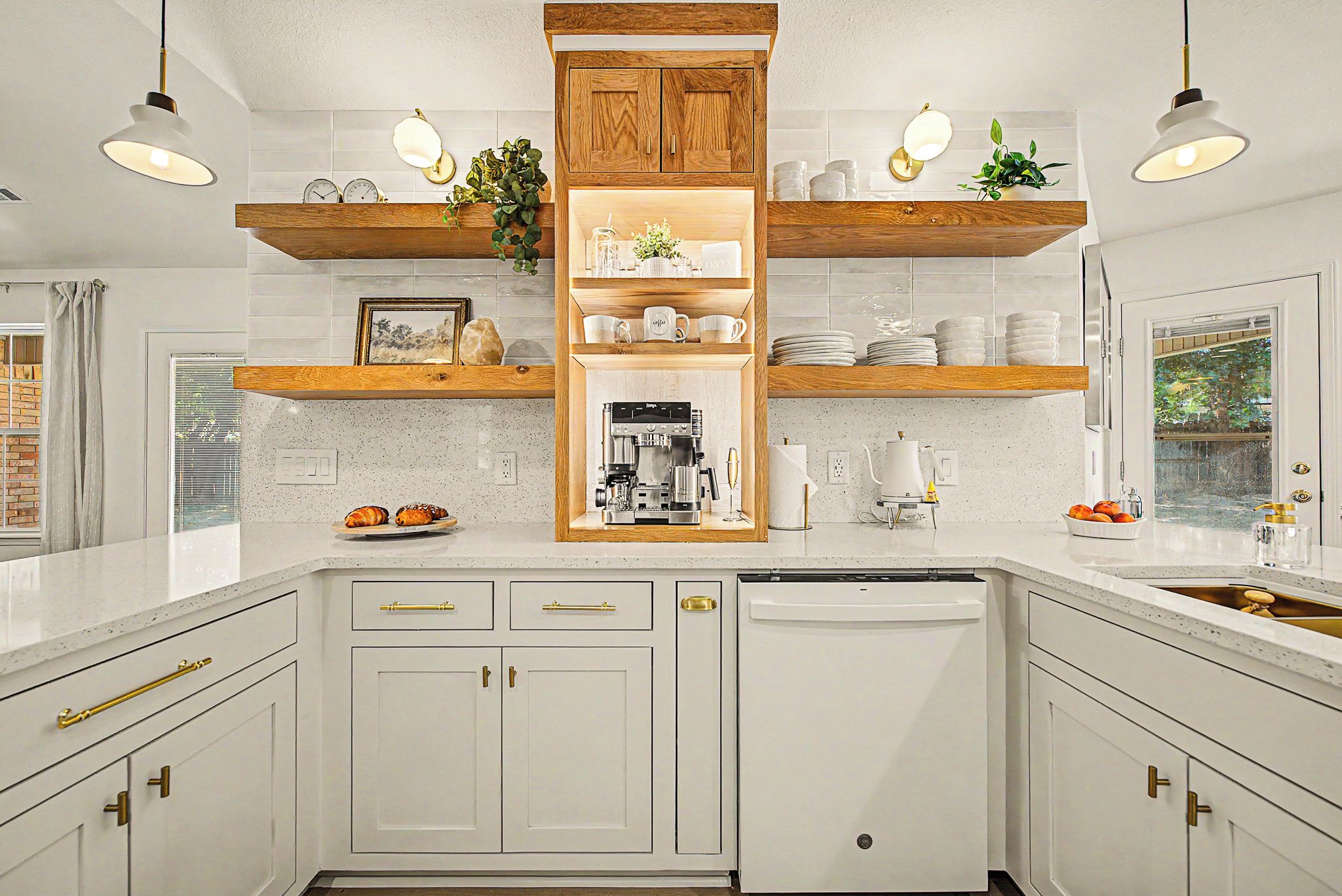 A kitchen with white cabinetry, wooden shelves, a coffee machine, and a dishwasher.