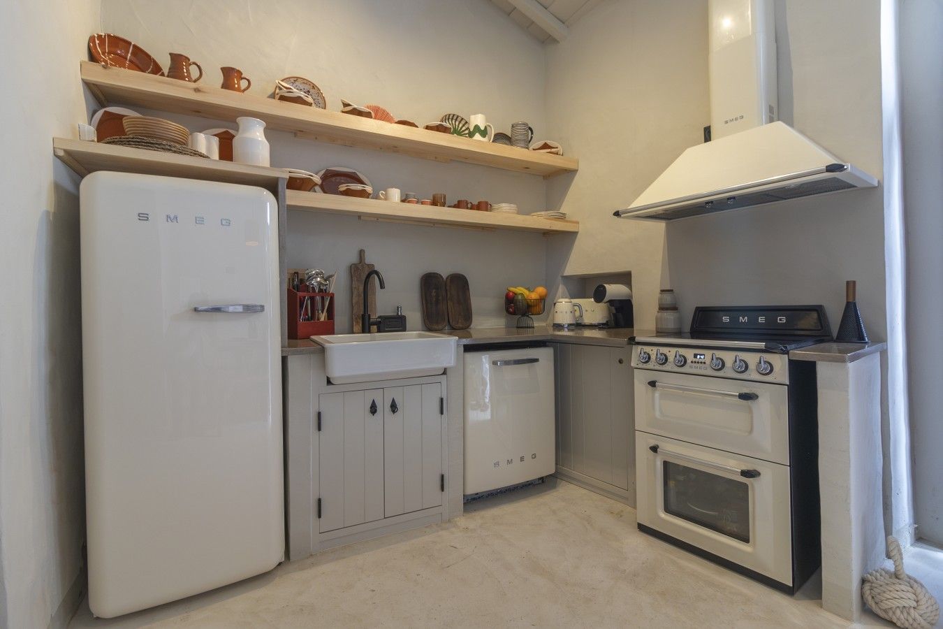 Una cucina compatta con un frigorifero bianco, un lavello e un piano cottura.