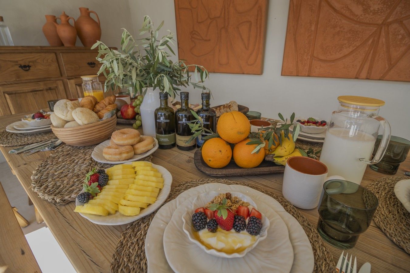 Una tavola imbandita per la colazione, con frutta, dolci e bevande.