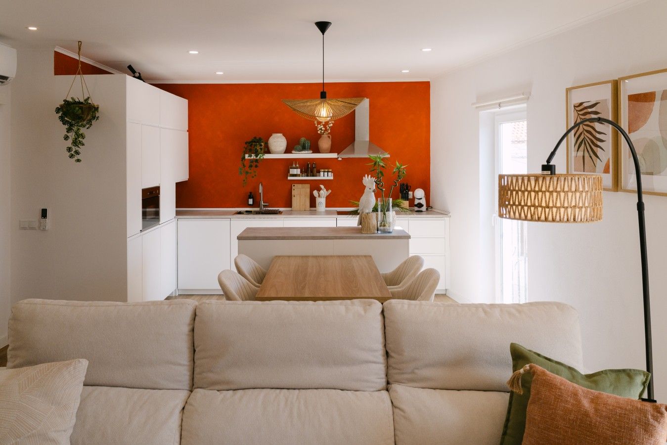 A modern living room with a sofa and a dining area in the background.