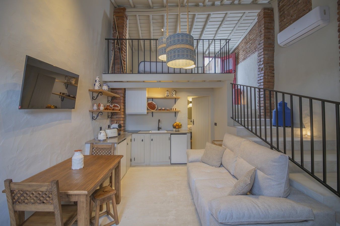 A compact living space with a dining area, kitchenette, and a sofa.
