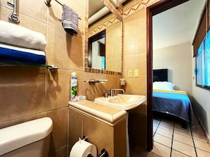 Un baño de hotel con inodoro, lavabo y perchero para toallas.