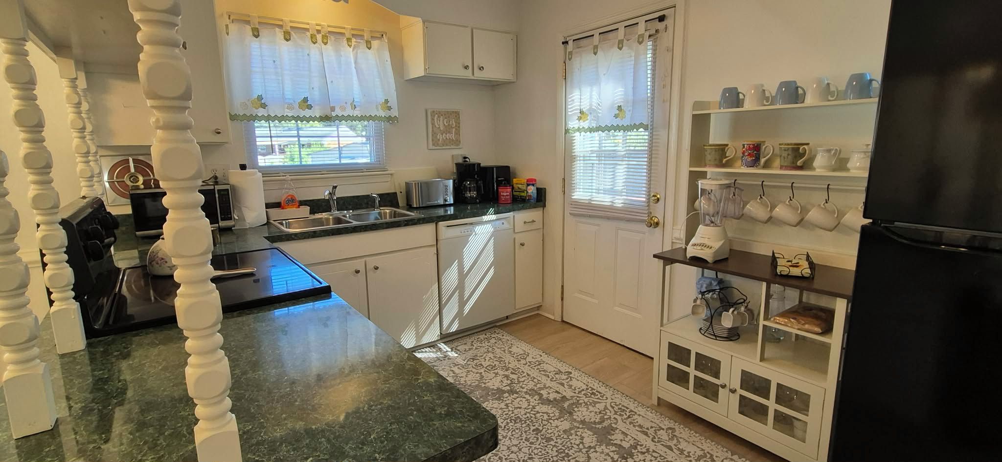 Una cocina equipada con lavavajillas, cafetera y refrigerador.