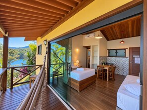 Une chambre avec un lit, un bureau et une vue sur un lac.