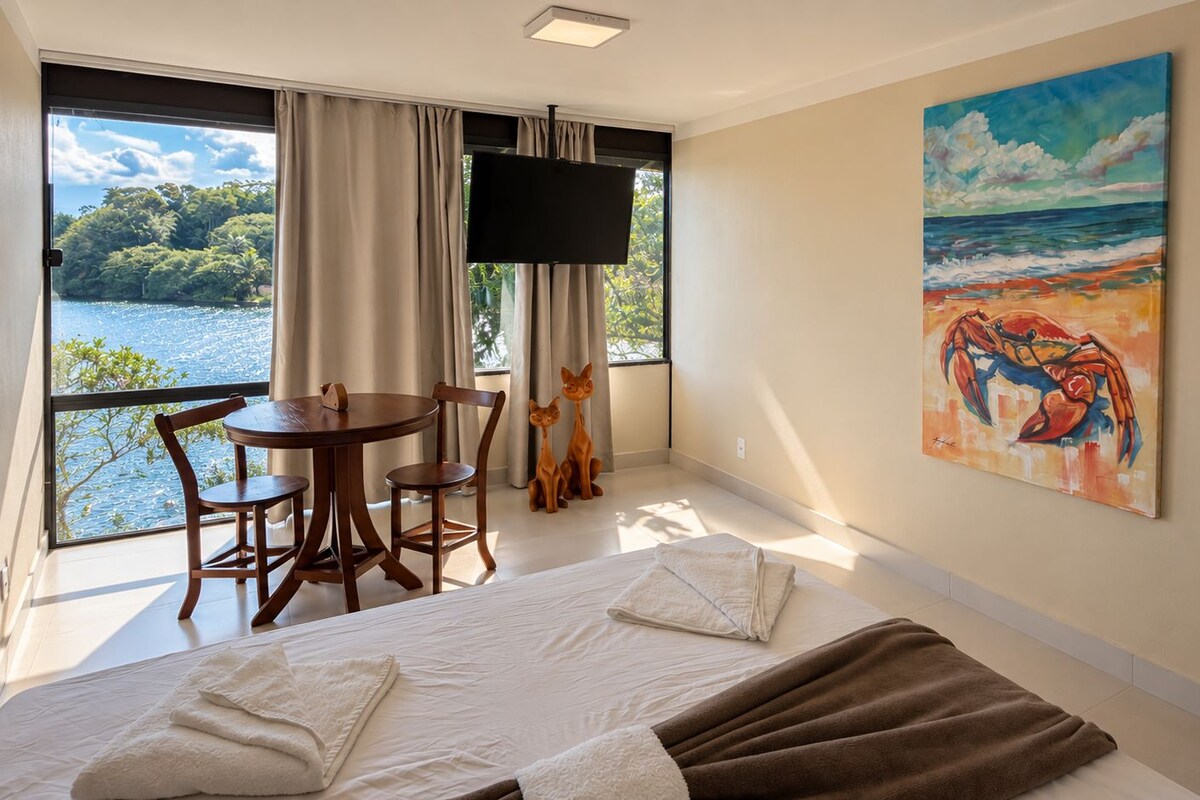 Une chambre d’hôtel avec un lit, une table, des chaises, une télévision et un tableau.