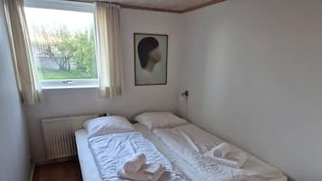 Ein Einzelzimmer mit Fenster, Heizkörper, Schreibtisch und Stuhl.