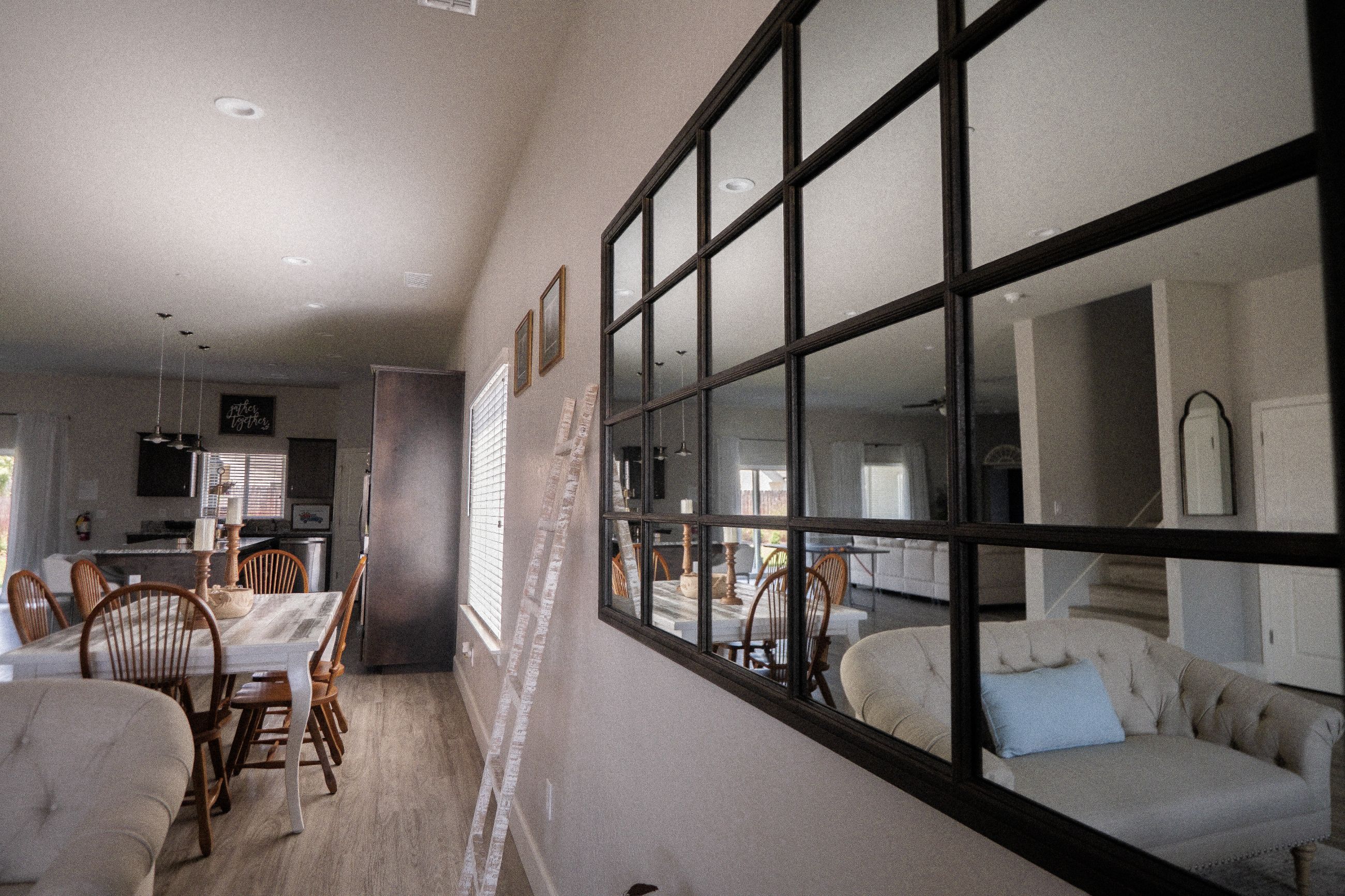 A spacious dining area with a large window, wooden chairs, and a table.