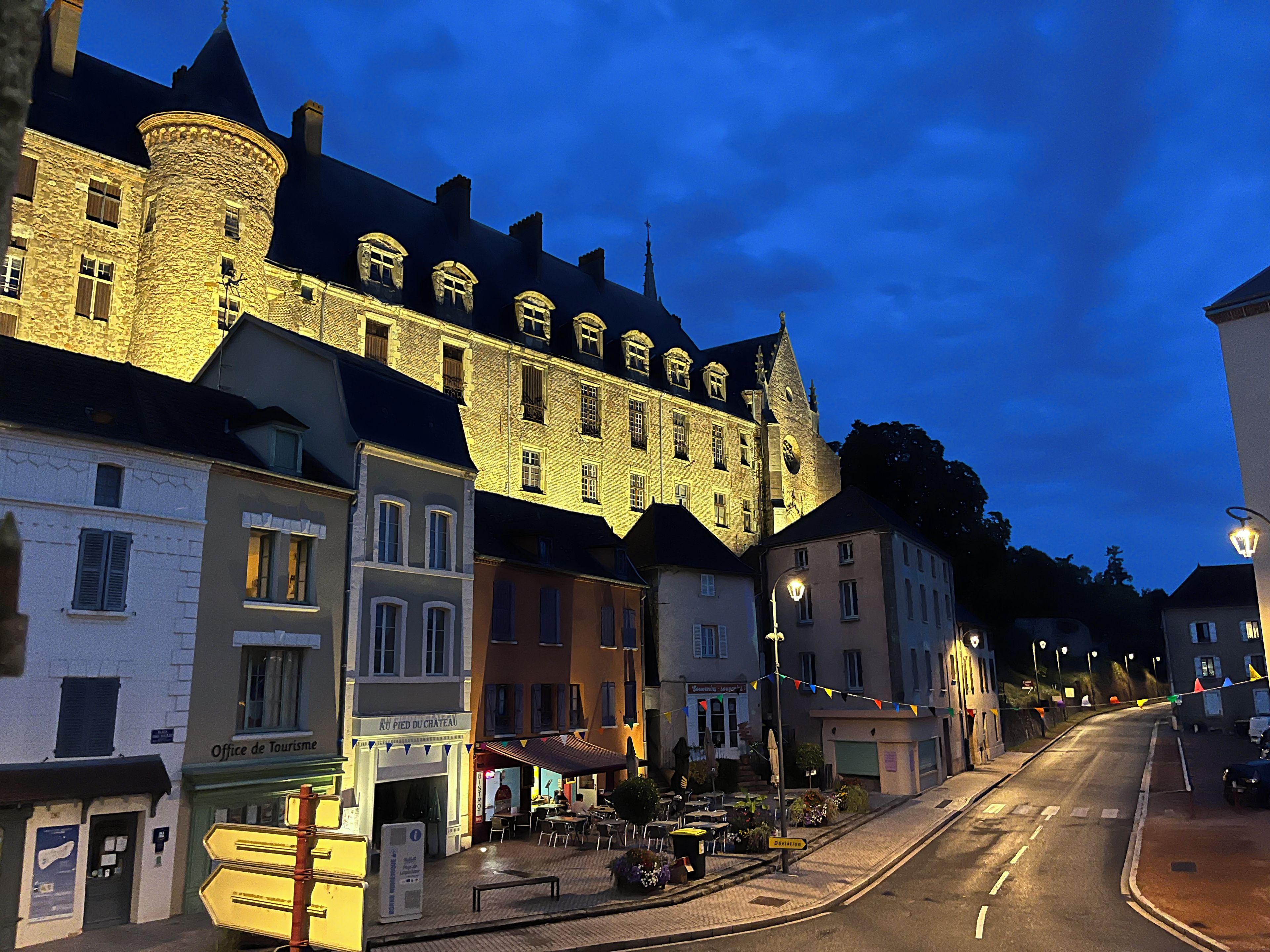 Un bâtiment historique doté d’une tour, d’un café et d’une enseigne indiquant l’emplacement de l’office de tourisme.