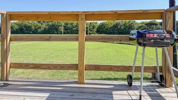 Een houten terras met een barbecue.