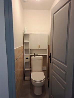 A compact bathroom with a toilet, a sink, and a cabinet. - New Listing (Le Val-Saint-Germain)