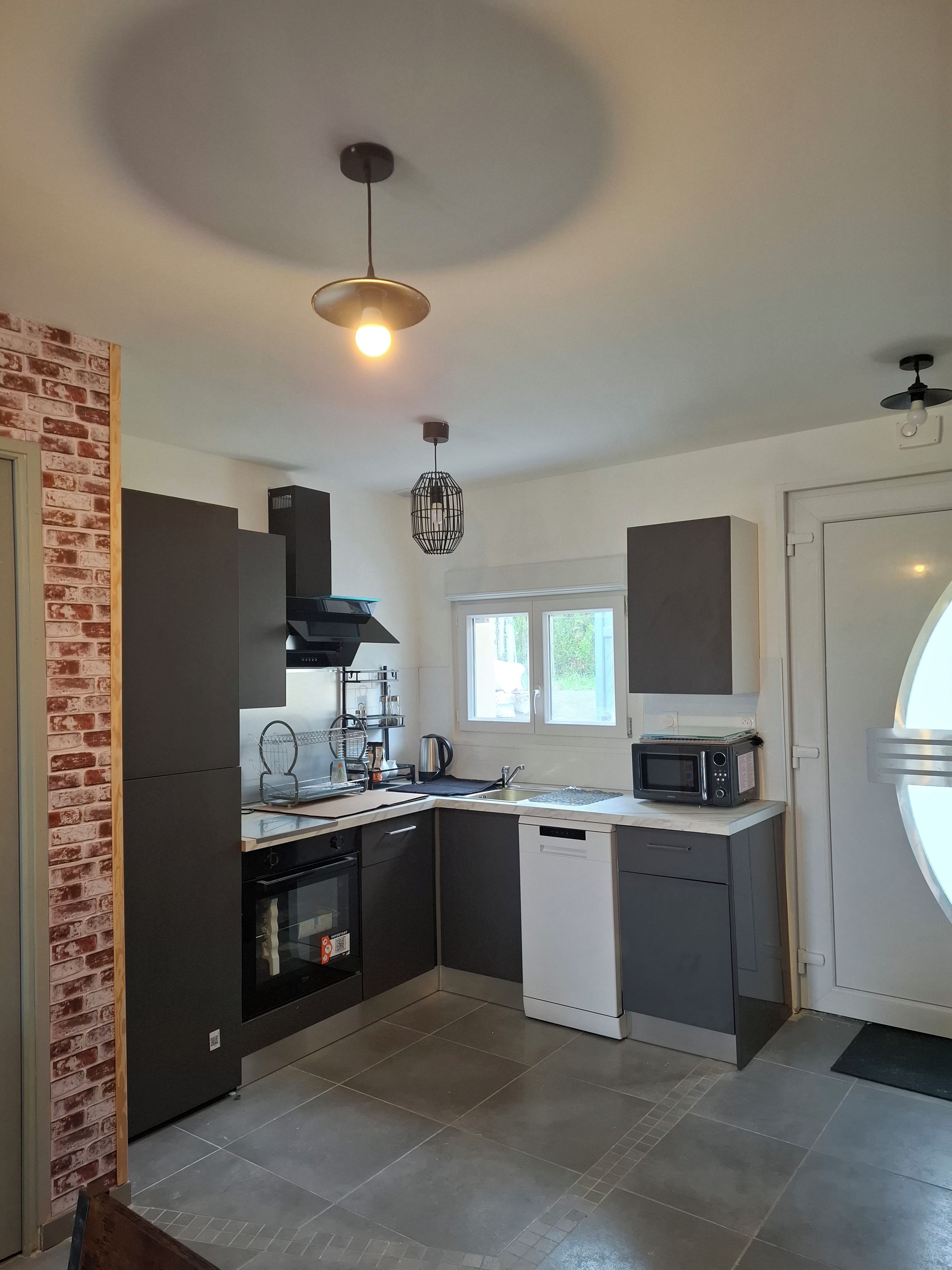 A modern kitchen with a built-in oven, microwave, and sink.