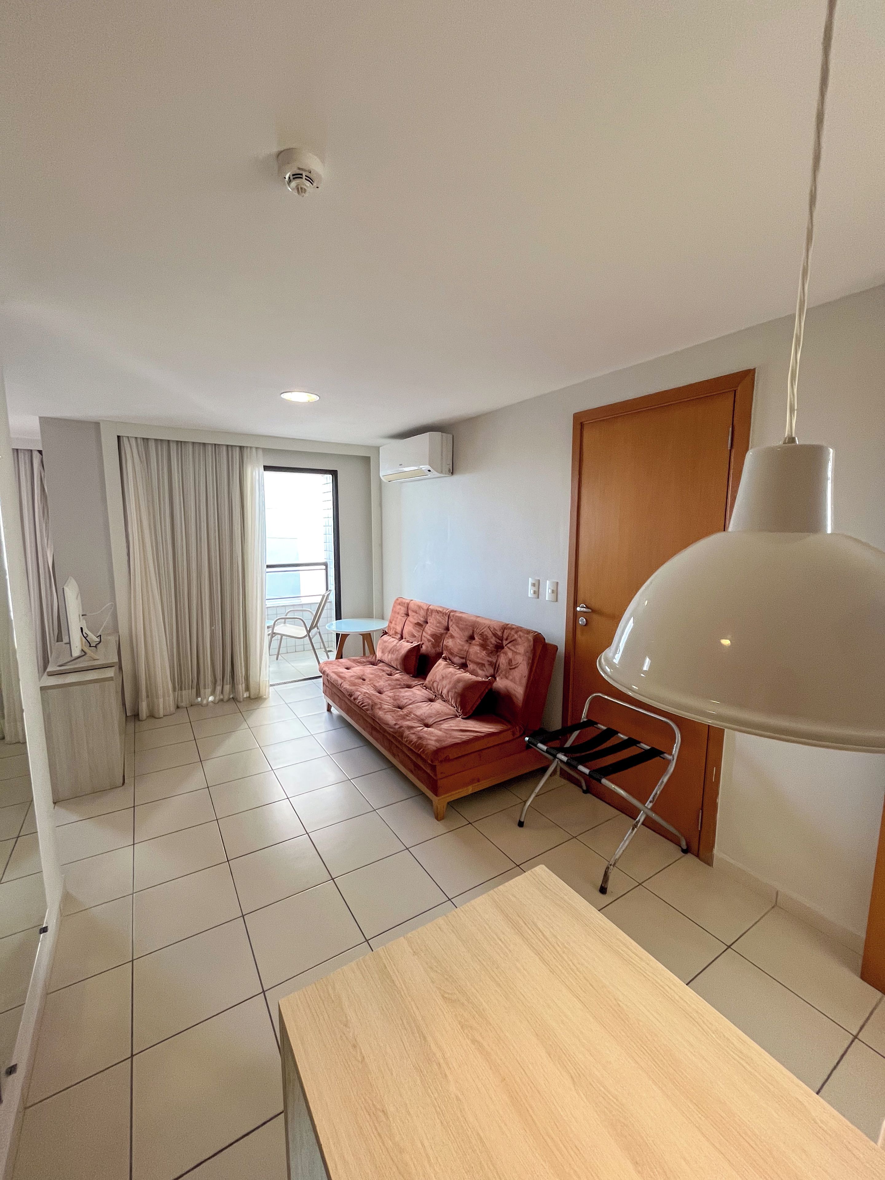 Una sala de estar moderna con un sofá, una mesa y una lámpara colgante.