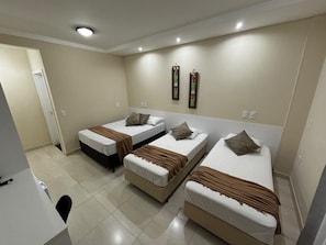 A hotel room with three single beds, a desk, and a chair. - POUSADA DA JAKE PRIME (Penha)