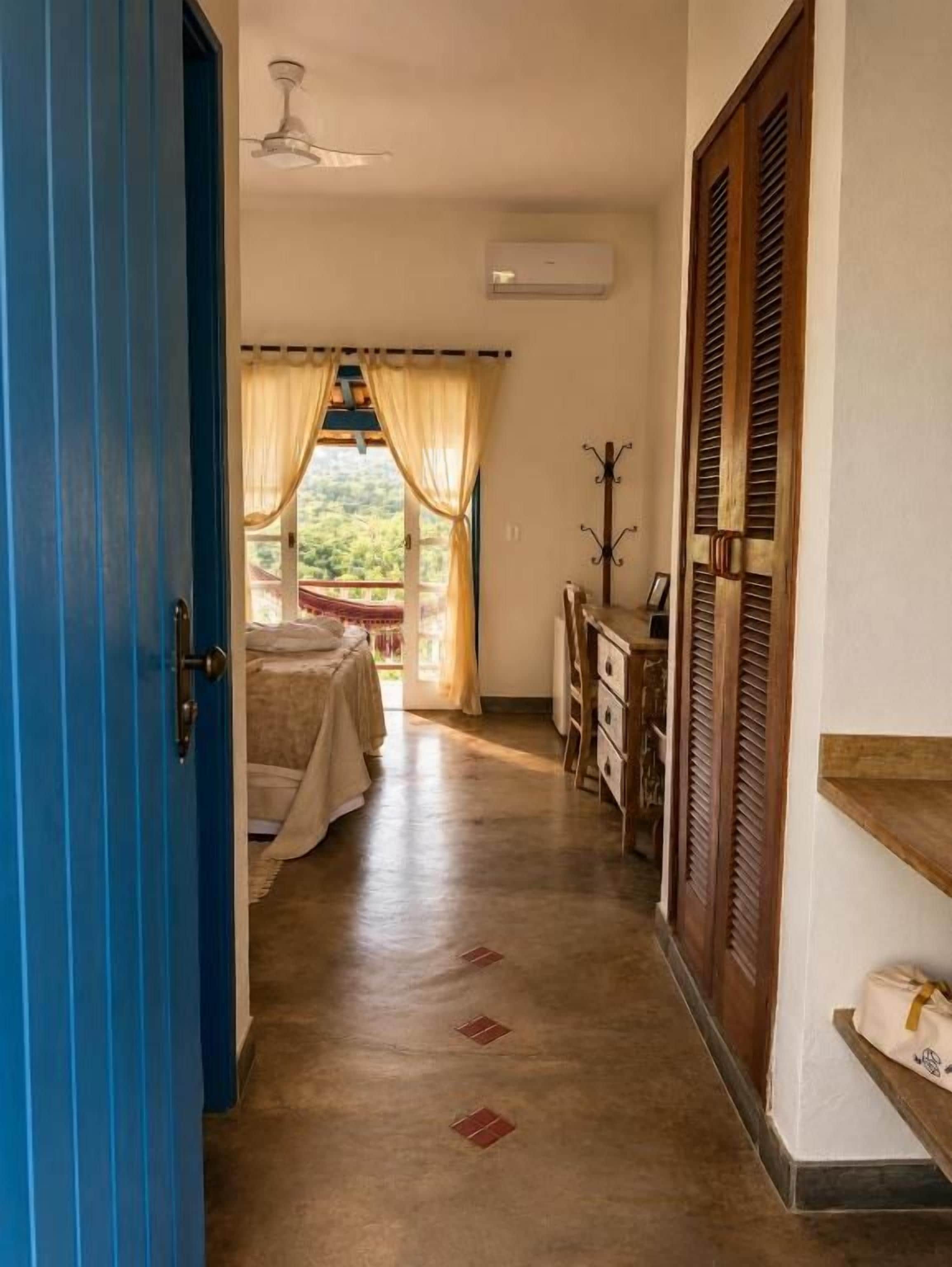 Un couloir comprenant un lit, une armoire et un ventilateur de plafond.