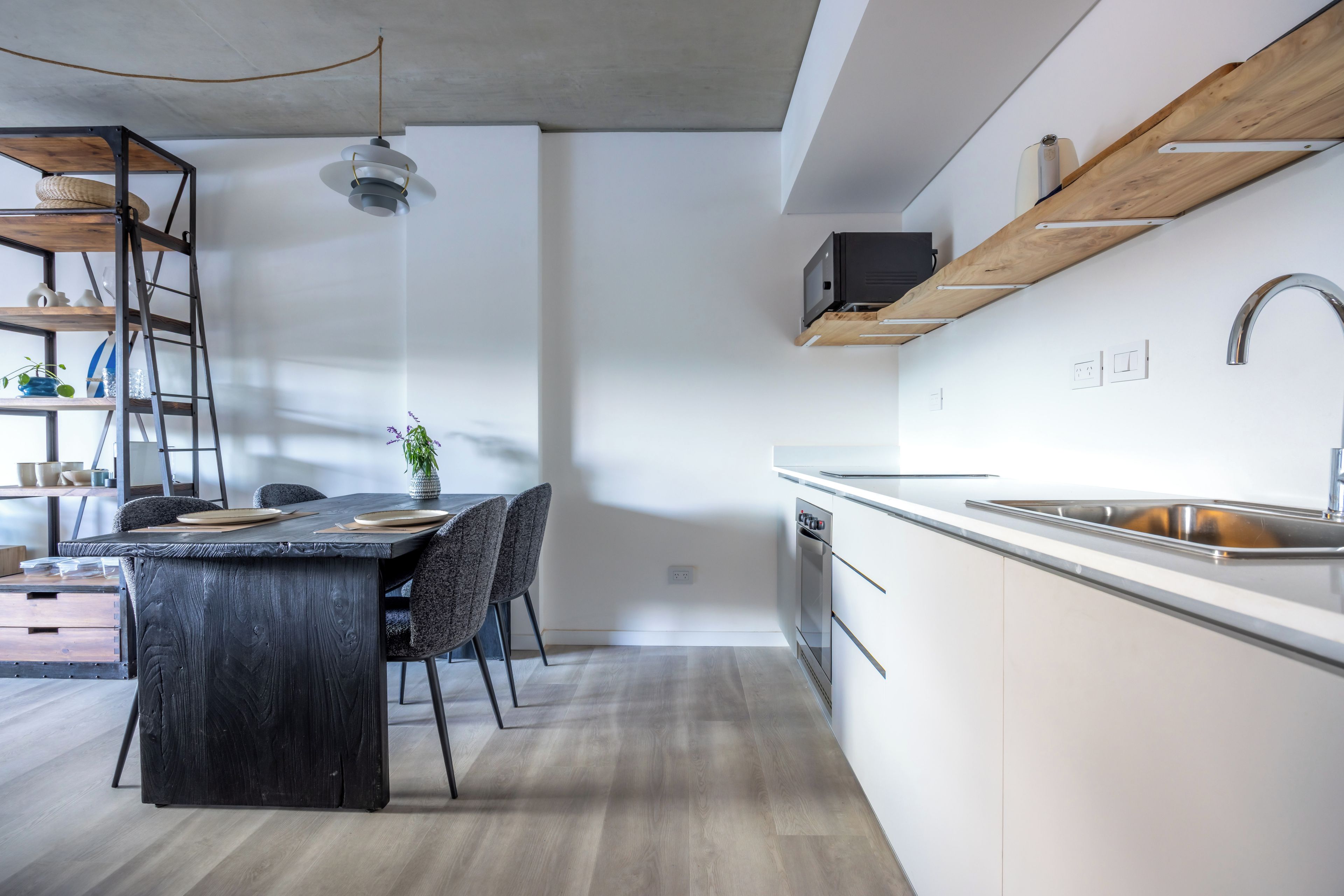 Une cuisine moderne dotée d’un îlot central, d’appareils électroménagers intégrés et d’un design minimaliste.