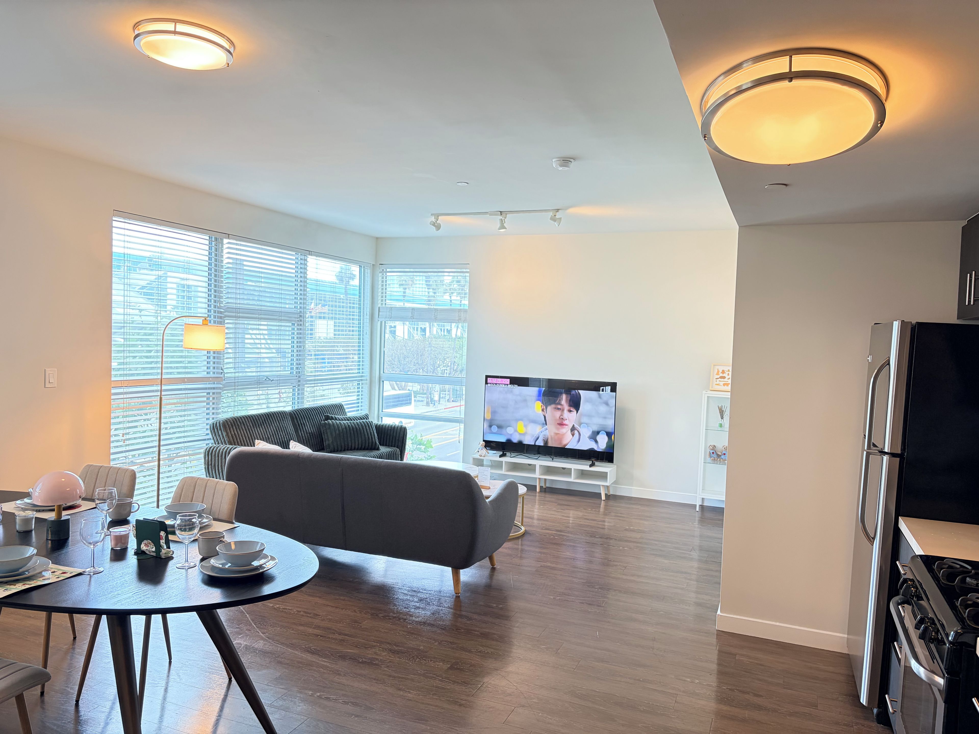 A modern living room with a sofa, dining table, and a TV.
